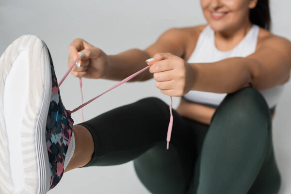 Сильный спортсмен завязывает шнурки, готовясь к целенаправленной тренировке.