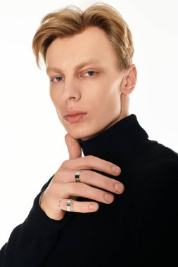 Genç ve yakışıklı bir adam içeride kendine güvenerek poz verirken cazibesini ve zarafetini sergiler..