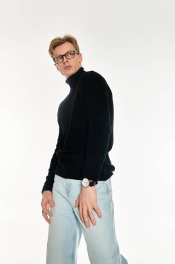 Şık bir genç adam kendine güvenerek duruyor, şık bir bakışla moda anlayışını sergiliyor..