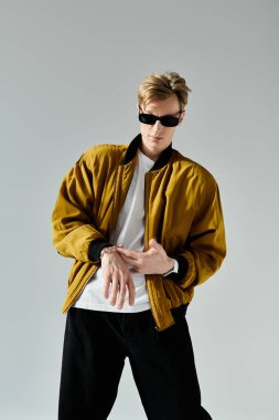 Çağdaş bir iç mekan ortamında, genç bir adam gündelik giyinirken kendine güven ve tarz yayar..