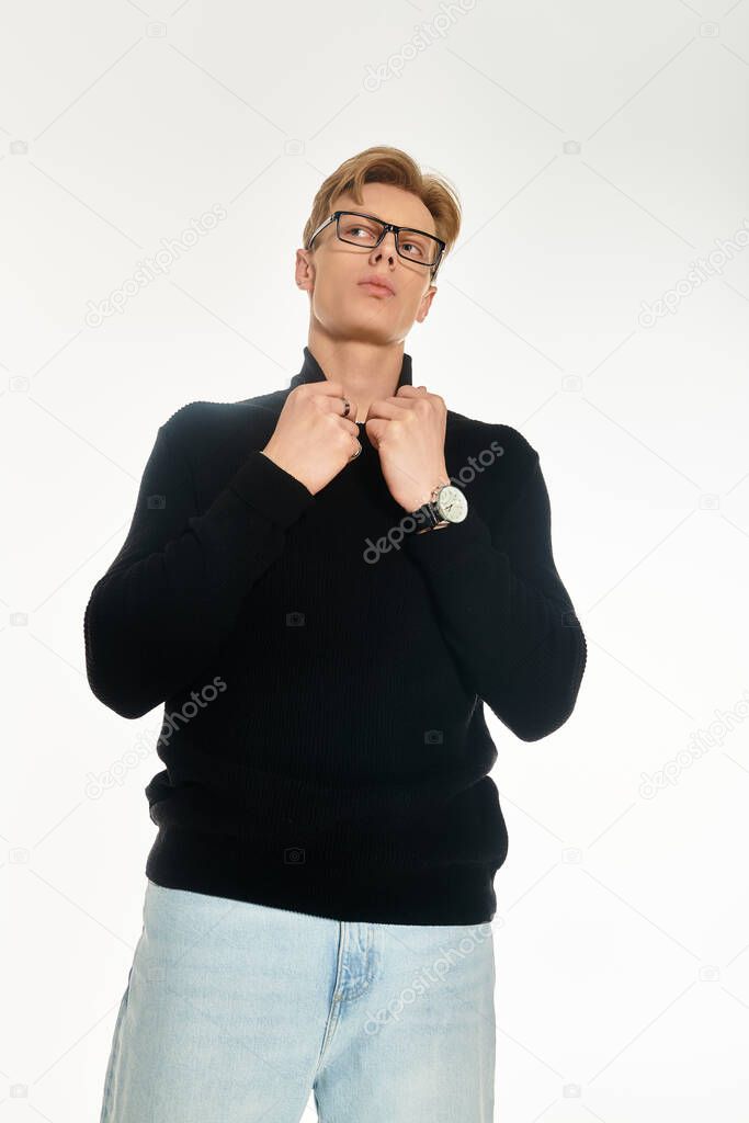 A handsome young man stands confidently, adjusting his collar while showcasing modern fashion.