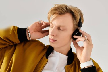 Kulaklıkla rahatlayan genç bir adam, düşüncelere dalmışken ritmin tadını çıkarıyor..