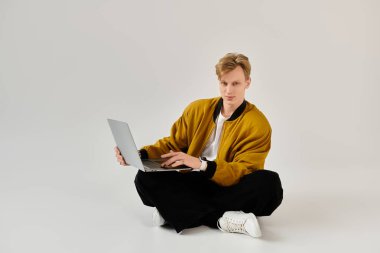 Kendine güveni tam genç bir adam dizüstü bilgisayarıyla yaratıcı işler yapıyor..