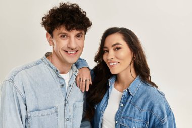 Modaya uygun genç bir çift, parlak bir stüdyoda çağdaş tarzlar sergiliyor..