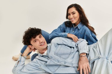 Tarz sahibi genç bir çift, uyumlu kot pantolon içinde rahatlar, özgüven ve modern yetenekler yayarlar..