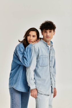 Genç çift hiç zorlanmadan kotlarını giyip modern moda havası yayıyor..