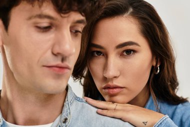 Genç çift, minimalist bir ortamda kendine güvenen ifadelerle moda sergiliyor..