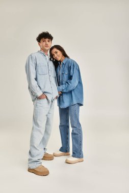 Genç çift modaya uygun kot giysiler içinde, modaya uygun ve modern bir estetiği somutlaştırıyor..