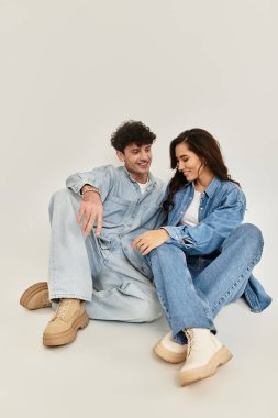 Tarz sahibi genç bir çift şık kot kıyafetleriyle neşeli bir anı paylaşıyor..