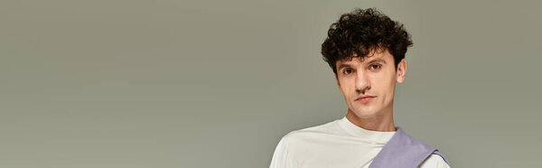 Fashion forward young person stands confidently, exuding style against a minimalistic backdrop.