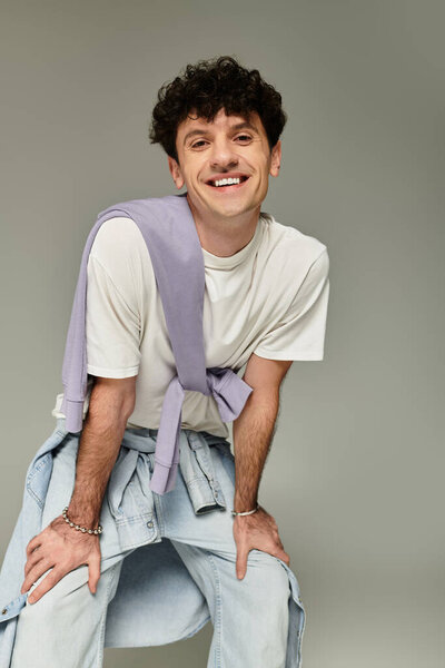 A young man exudes confidence and style, dressed in trendy casual attire with a creative twist.