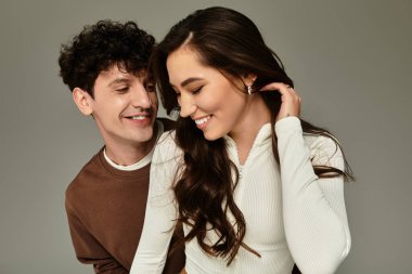 Genç bir çift şık kıyafetlerini sergilerken kapalı alanlarda eğlenceli etkileşimler kuruyor..