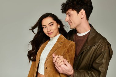 Genç bir çift, modaya uygun kıyafetler, ışık saçan bir tarz ve çağdaş çekicilik takınıyor..