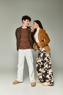 A fashionable pair poses confidently in trendy outfits, capturing the essence of contemporary style. clipart