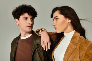 Moda ikilisi, şık ve minimalist bir stüdyoda poz verirken çağdaş tarzını sergiliyor..