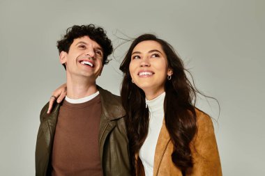 Şık genç bir çift şık bir ortamda kıyafetlerini gösterirken güler..