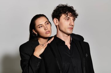 Modern bir ortamda, modaya uygun bir ikili, birbirine yakın poz verirken stiller sergiliyor..