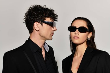 Minimalist bir arka plana karşı şık çift modelleri moda güneş gözlükleri.