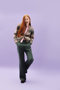 Kimliğini cesurca ifade eden genç, eşcinsel bir adam, yumuşak, mor bir arkaplana karşı güvenle poz verir..