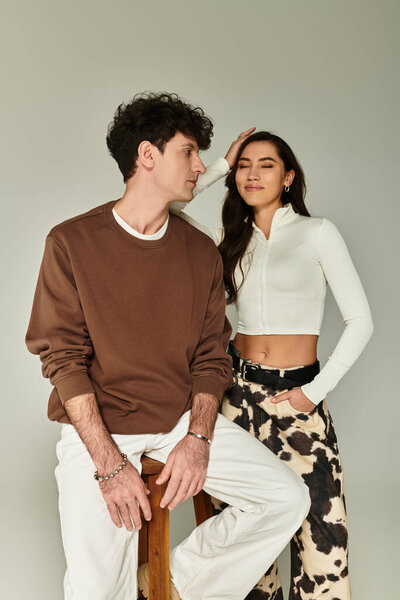 A young couple poses stylishly, showcasing modern fashion with effortless charm.