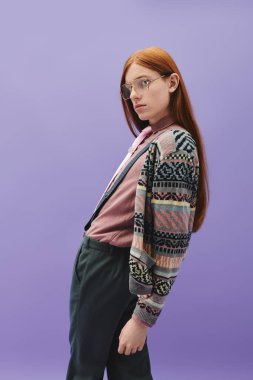 Şık, uzun kızıl saçlı moda bir birey çarpıcı bir ortamda şık bir görünüm sunar..