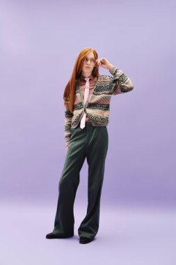 Uzun kızıl saçlı tuhaf bir genç adam yaratıcı bir ortamda şık kıyafetini sergiliyor..