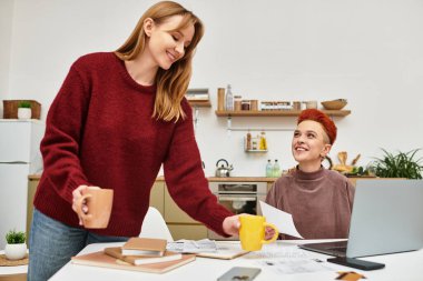 İki kadın evde birlikte çalışırken aynı kahkahayı ve sıcaklığı paylaşıyor..