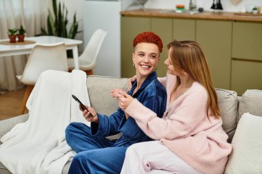 İki genç kadın modern dairelerinde birlikte rahatlıyor, kahkahalarını ve sevgilerini paylaşıyorlar..