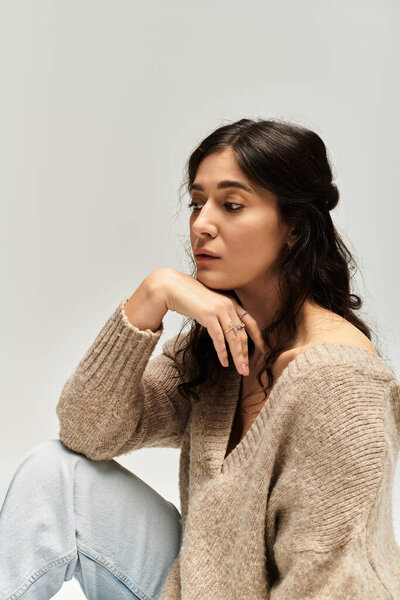 Уверенность и элегантность сияют на красивой плюс размер женщины в бежевом свитере.