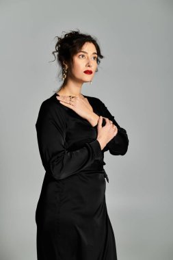 Stüdyoda gri bir arka planı olan iri yarı bir kadının büyüleyici zarafeti..