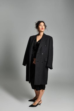 Şık giyinmiş zarif genç bayan stüdyo ortamında zarifçe poz veriyor..