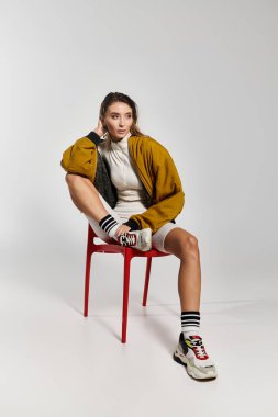 Zarif moda yönetmeninin şık giyinme tarzını minimalist bir ortamda sergilemesi.