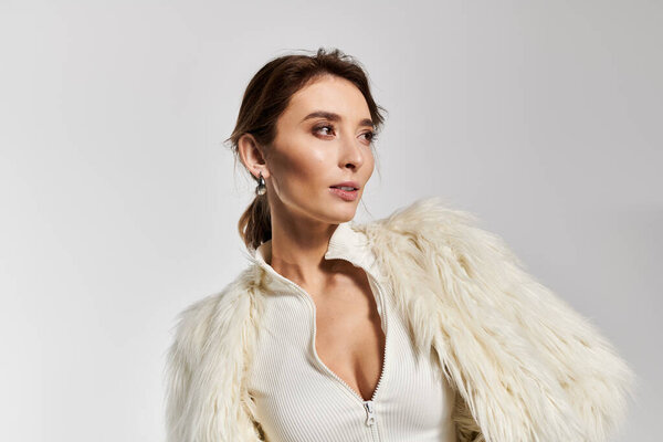 Elegant young woman showcasing chic attire style in a modern studio setting.