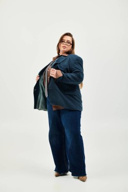 Güzel ve iri bir kadın, şık kıyafetini içeride ayarlarken kendine güvenir bir şekilde poz verir..