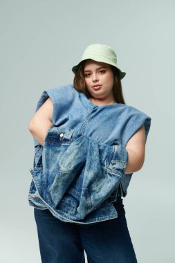 Genç ve iri bir kadın, kot giyerken moda anlayışını sergiliyor..