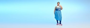 A beautiful plus size woman poses elegantly against a blue backdrop, flaunting her style. clipart