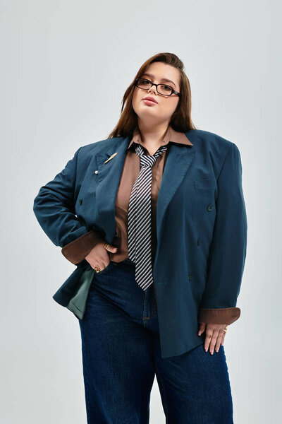 Young woman flaunts her style in an oversized blazer and chic tie, exuding confidence.