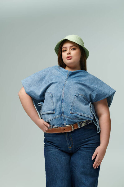 Beautiful woman showcases a trendy denim ensemble paired with a playful green bucket hat.