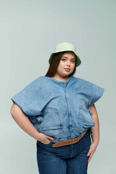 A beautiful young plus size woman poses confidently in trendy denim, showcasing her personal style.