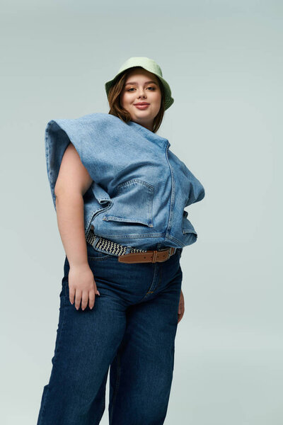 A young plus size woman proudly showcases her unique style with confidence, sporting a denim outfit.
