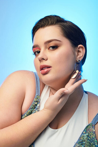Young plus size woman radiates confidence with a striking expression and bold makeup.