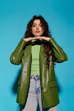 Modaya uygun genç bir kadın kendine has tarzını cesur yeşil elbisesi ve çarpıcı duruşuyla sergiliyor..
