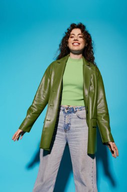 Kendinden emin genç bir kadın canlı yeşil kıyafetini sergiliyor. Canlı bir ortamda neşe saçıyor..