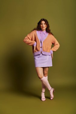 Şık bir kadın, kendine güveni tam, renkli bir hırkayla eşsiz görünüşünü sergiliyor..