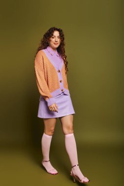 Genç bir kadın moda anlayışını renkli bir kıyafetle sergiliyor. Kendine güveni ve cazibesi var..