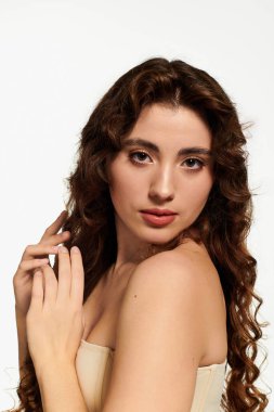 Güzel, genç bir kadın zarif bir şekilde poz veriyor. Moda tarzını ve göz alıcı özelliklerini vurguluyor..