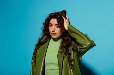 Güzel genç bir kadın, moda anlayışını yeşil bir elbiseyle, ışıltılı bir stil ve cazibeyle sergiliyor..