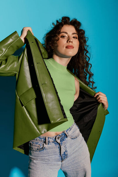 Уверенная молодая женщина в ярко-зеленом топе и куртке позирует с чутьем, излучая радость.