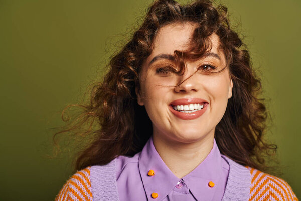 Молодая, модная женщина излучает радость своей сияющей улыбкой, демонстрируя непринужденный стиль и обаяние.