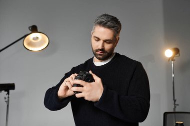 Yetenekli bir sanatçı modern bir stüdyoda bir projeye hazırlanırken kamera ayarlarını ayarlar.